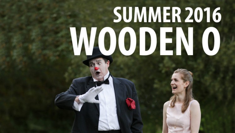 A woman laughs at a man dressed as a clown in a fancy suit